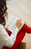 woman in white and red holding notebook